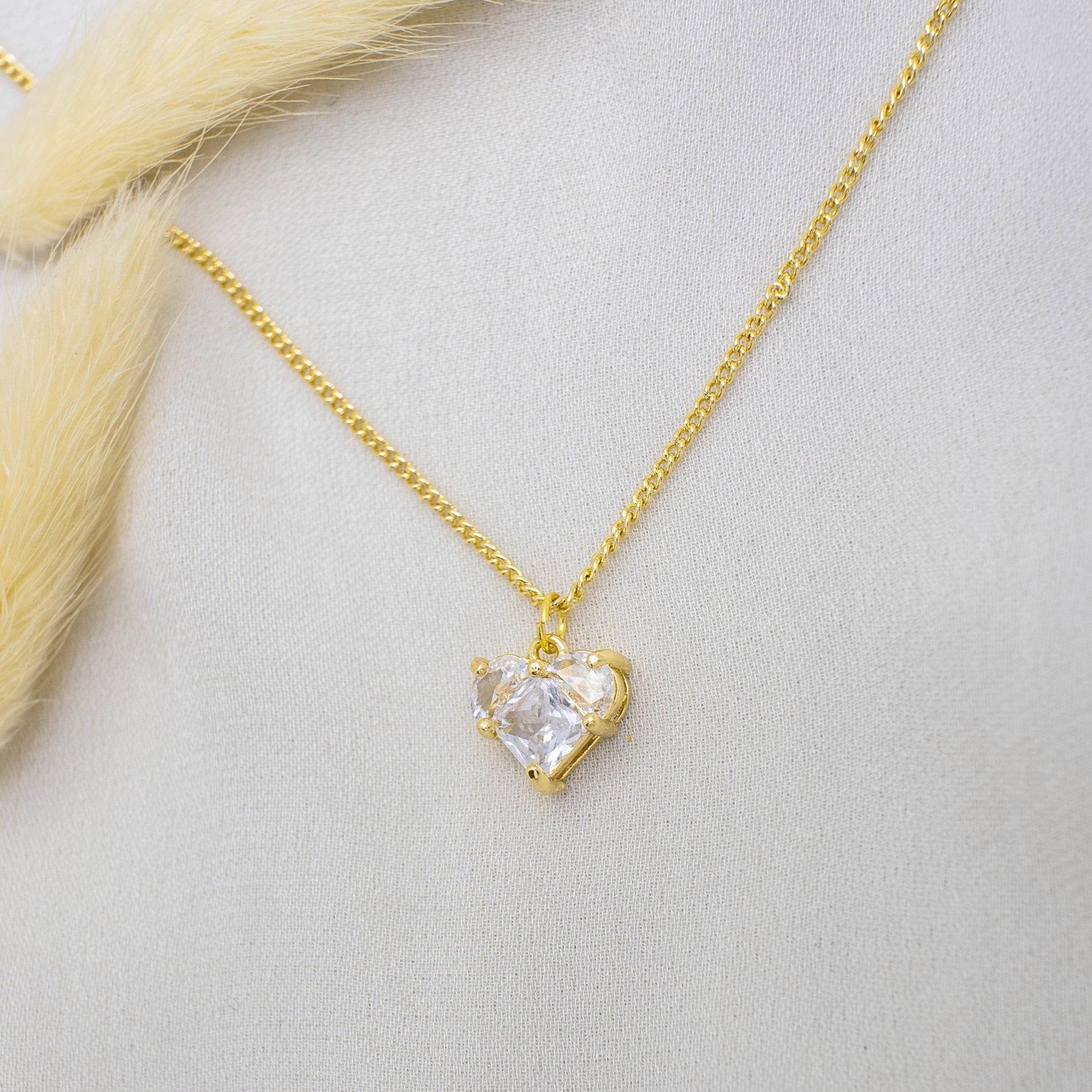 This photo features a thin chain necklace made of 14K gold-plated sterling silver, paired with a zircon heart charm.