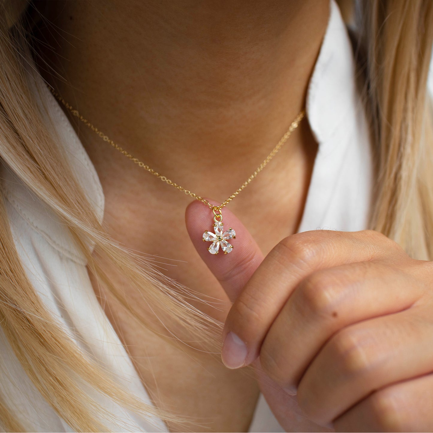 This photo features a thin chain necklace made of 14K gold-plated sterling silver, paired with a zircon Flower charm.