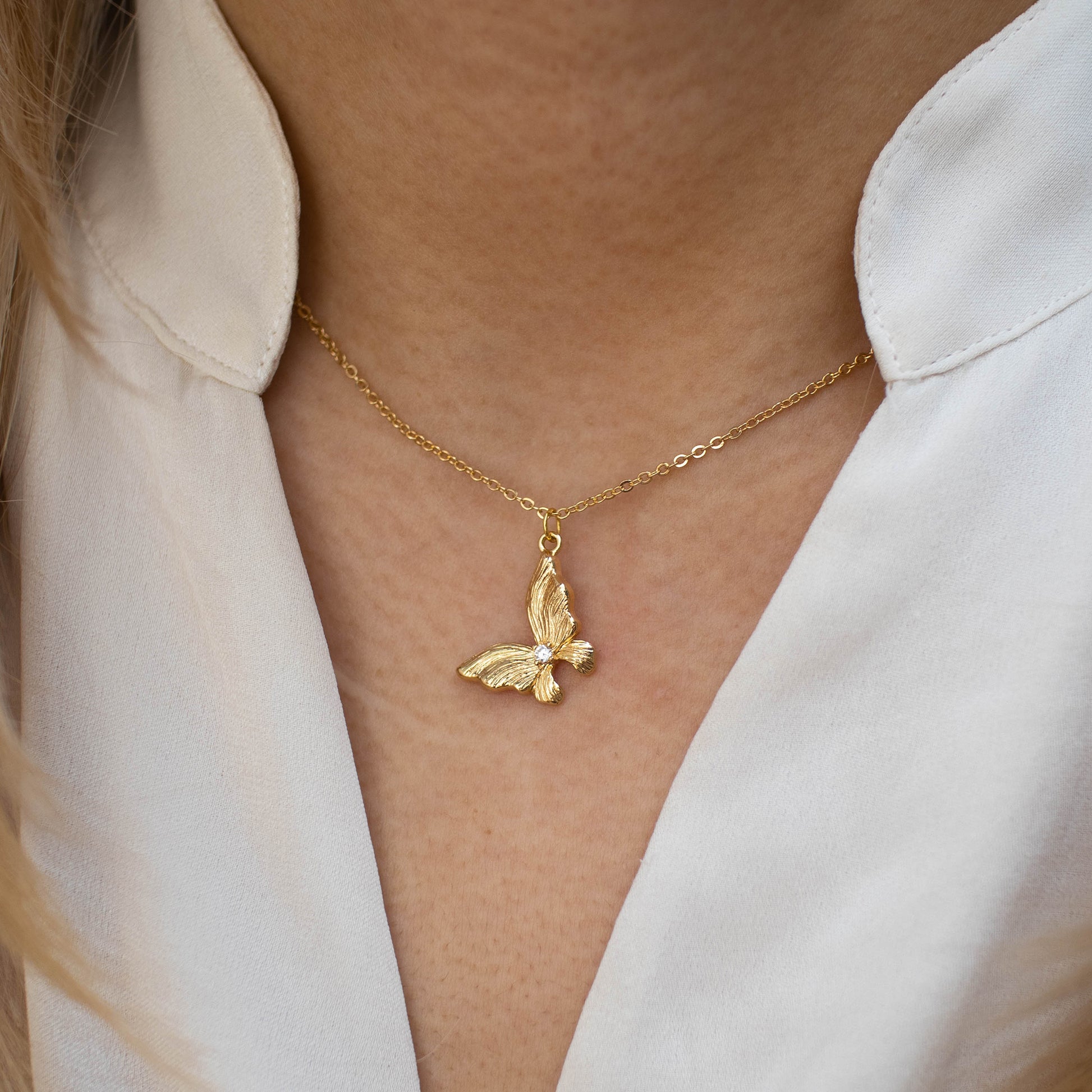 This photo features a thin chain necklace made of 14K gold-plated sterling silver, paired with Gold Butterfly Necklace