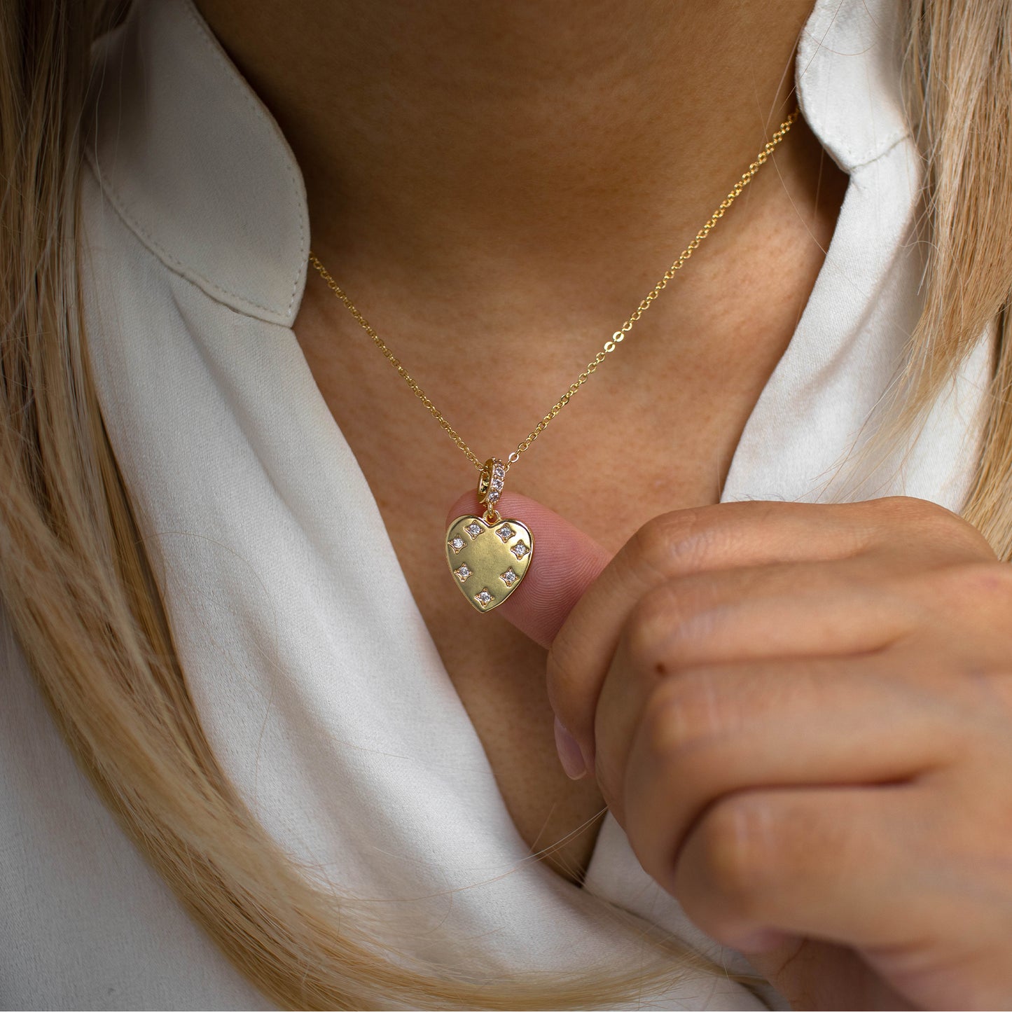 This photo features a thin chain necklace made of 14K gold-plated sterling silver, paired with zircon heart necklace