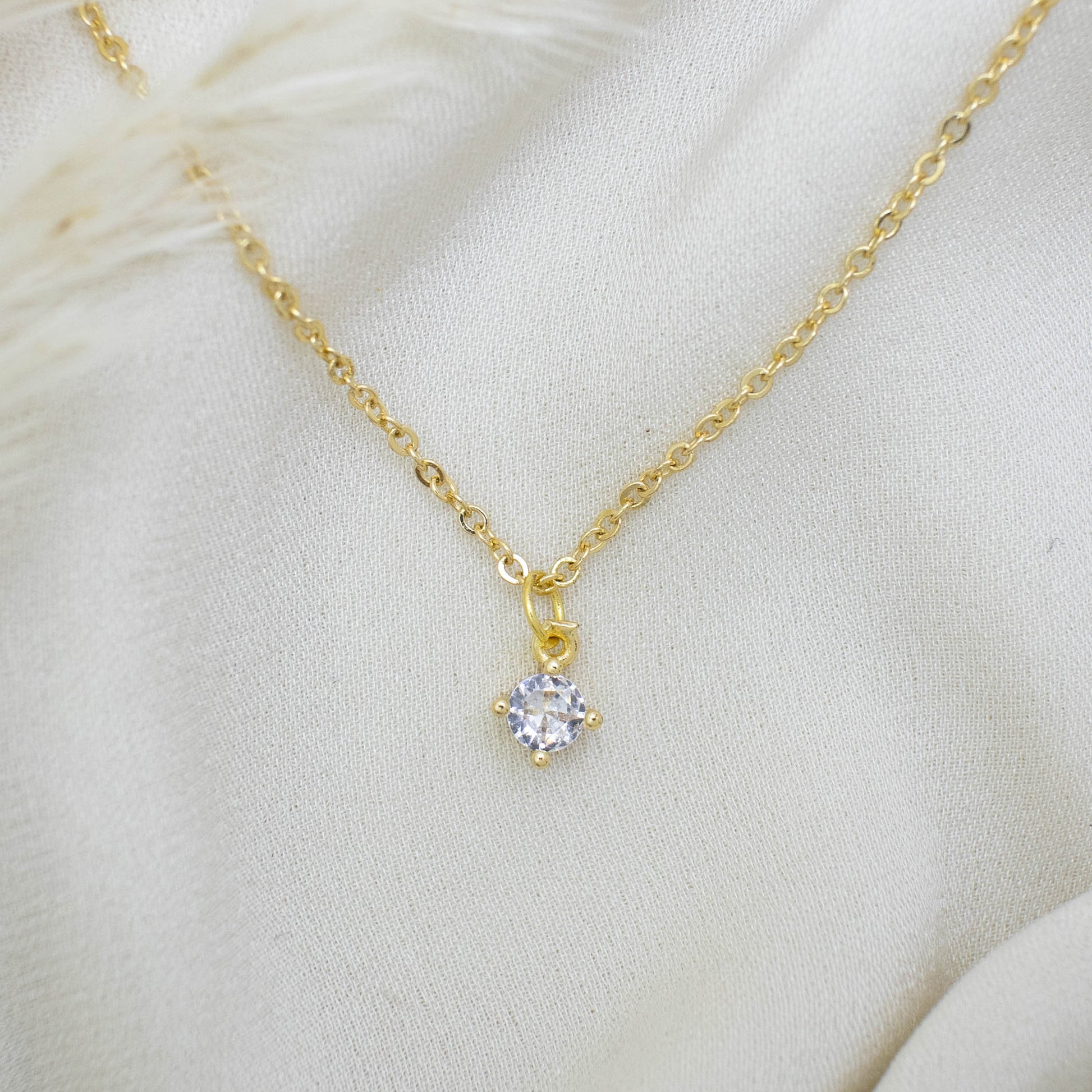 This photo features a thin chain necklace made of 14K gold-plated sterling silver, paired with Round Zircon Necklace