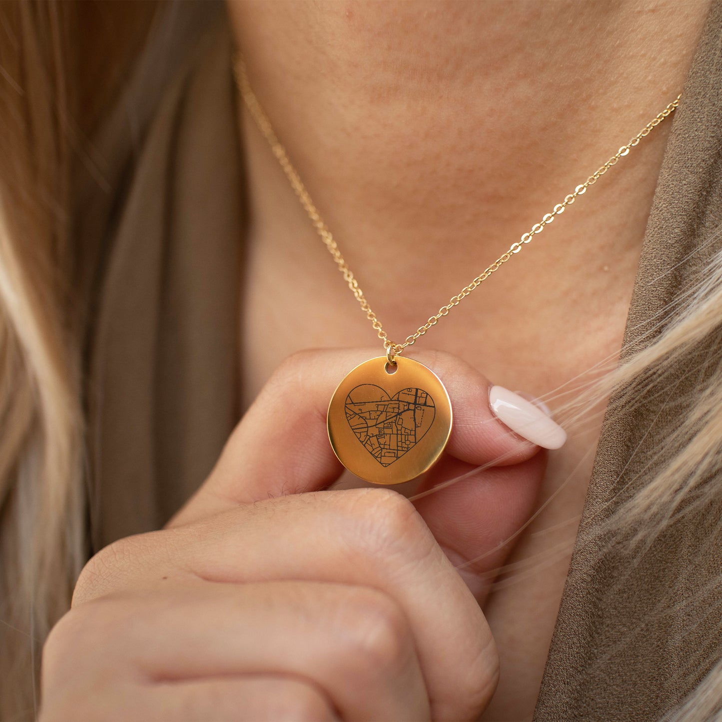 This photo features a thin chain necklace made of 14K gold-plated Brass, paired with a heart-shaped map charm.