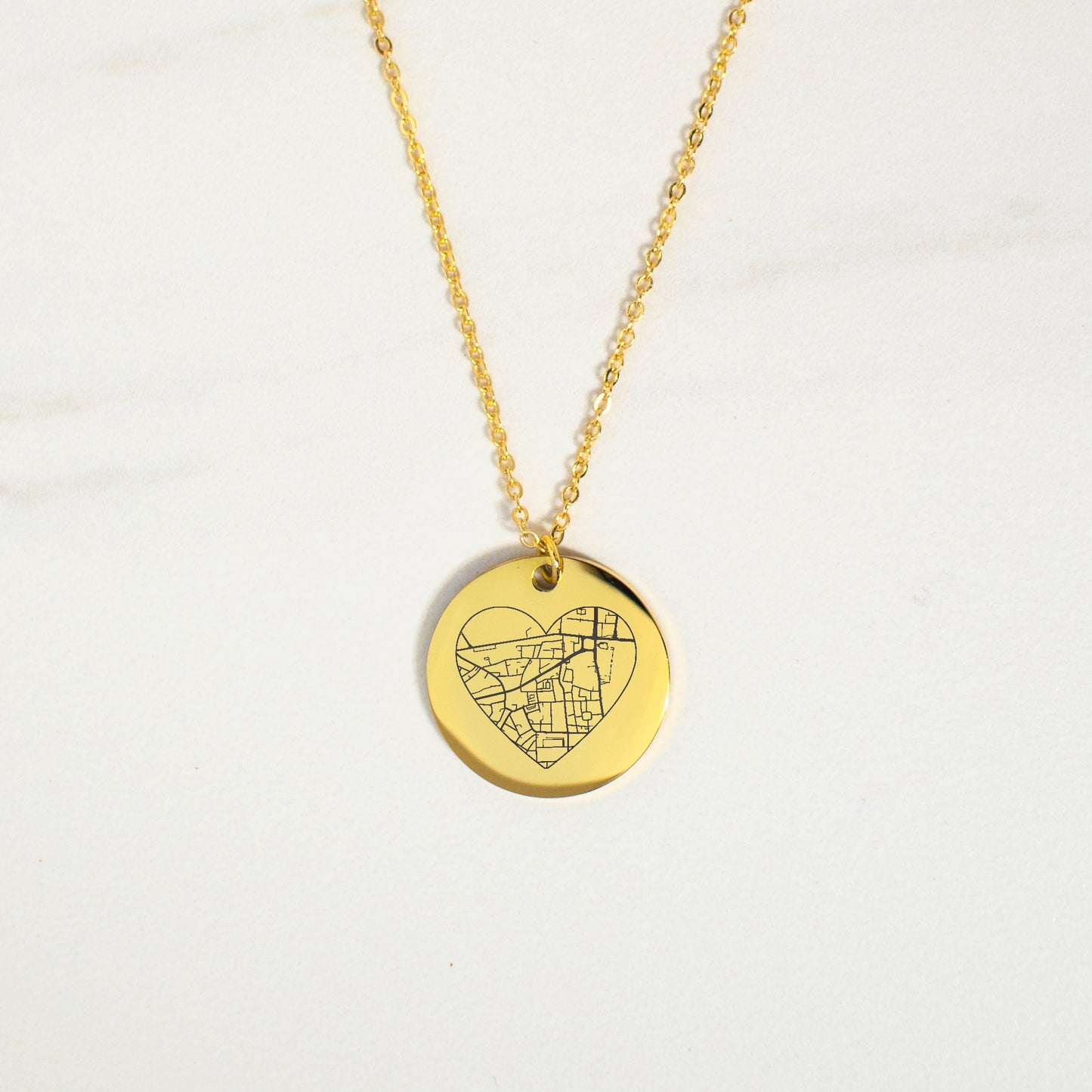 This photo features a thin chain necklace made of 14K gold-plated Brass, paired with a heart-shaped map charm.