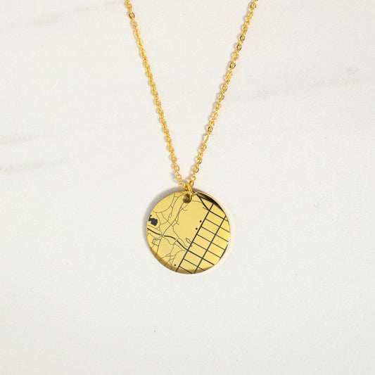 This photo features a thin chain necklace made of 14K gold-plated Brass, paired with a circle map charm.